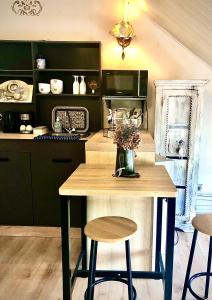 a kitchen with a table and two stools in it at La Porte Bleue le grenier des Anges in Saint-Pierre
