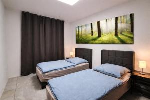 two beds in a bedroom with a painting on the wall at Gästehaus Ferienwohnung Wohnung#3 Jülich in Jülich