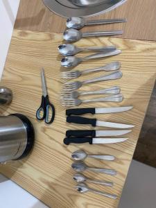 a wooden cutting board with several knives and scissors at Hôtel Brasserie Le Lion d'Or in Meximieux