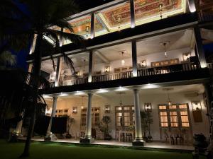 a lit up building with a balcony at night at Wilson's Place in Hiriketiya