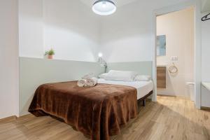 a white bedroom with a bed with a brown blanket at FORUM EXPERIENCE Adults Only in Tarragona