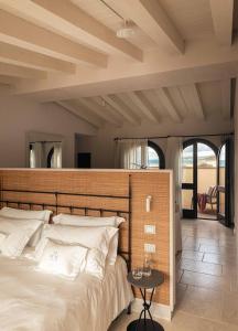 a bedroom with a large bed with a wooden headboard at Hotel Le Dune Piscinas in Ingurtosu +105 photos