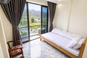 a bedroom with a bed and a balcony at Kiên Bin Đồng Văn Hotel in Dồng Văn