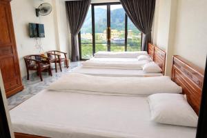 a row of beds in a room with a window at Kiên Bin Đồng Văn Hotel in Dồng Văn