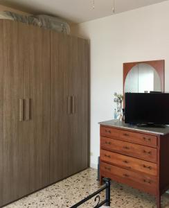 a bedroom with a wooden dresser with a tv on it at Appartamento "In viaggio come a casa" vicino alla Stazione, LTScalo! in Monticchio