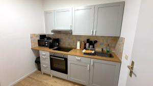 a small kitchen with white cabinets and a sink at Bitterfeld Apartment modern & gemütlich in Holzweißig
