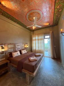 a bedroom with a bed with a painted ceiling at Wilson's Place in Hiriketiya