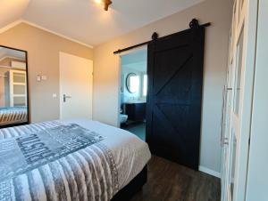 a bedroom with a bed and a large door at Vakantiewoning aan Zee in Zoutelande