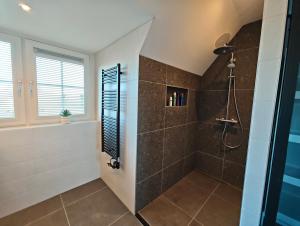 a bathroom with a walk in shower next to a glass door at Vakantiewoning aan Zee in Zoutelande +13 photos