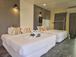 two beds in a hotel room with towels on them at Island Sea One Resort in Panglao Island +7 photos