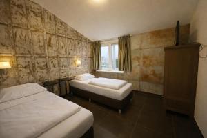 a hotel room with two beds and a window at Group accommodation De Beemster with Sauna | 14 persons in West-Graftdijk +13 photos