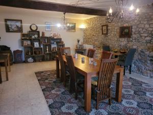 a dining room with a wooden table and chairs at Chambre d'hôtes Le Puy Maury in Augne