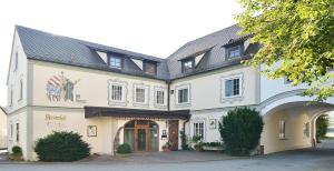 Hotel Restaurant Klosterhof في Gutenzell-Hürbel: مبنى ابيض كبير بسقف اسود