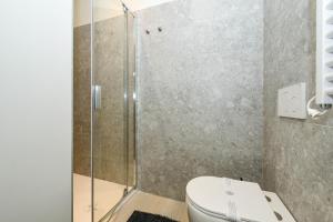 a bathroom with a toilet and a glass shower at Desenzanoloft Garda Golden Sunrise official partner Homes and Villas By Marriott Bonvoy in Desenzano del Garda +24 photos