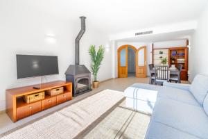 a living room with a blue couch and a fireplace at Villa Ocells II in Puigderrós +20 photos