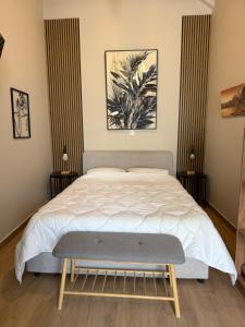 a bedroom with a bed with a bench in it at BYZANTIUM APARTMENTS in Ermoupoli
