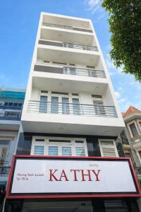 a tall white building with a sign in front of it at Kathy Hotel in Ho Chi Minh City