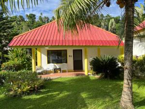 a yellow and red house with a red roof at Pintuyan Dive Resort in Pintuyan