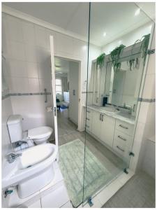 a bathroom with a toilet and a sink and a shower at The Estuary Country Estate, Villa "Once Upon A Tide" in Port Edward