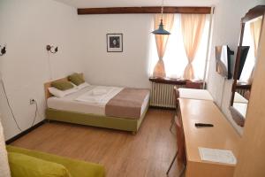 a small bedroom with a bed and a dresser and window at ApartHotel Kopaonik in Brzeće
