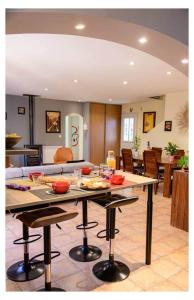 a kitchen and living room with a table with food on it at la villa "Loane" à St Paul trois Chateaux in Saint-Paul-Trois-Châteaux