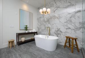 a bathroom with a white tub and a marble wall at Top Floor Penthouse Lofts in Atlanta