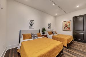 a bedroom with two beds with orange sheets at Top Floor Penthouse Lofts in Atlanta