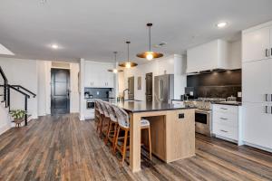 a kitchen with white cabinets and a large island with bar stools at Top Floor Penthouse Lofts in Atlanta +96 photos