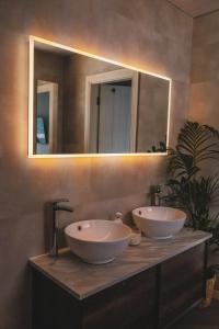 a bathroom with two sinks on a counter with a mirror at Smiley's Cottage in Doagh +26 photos