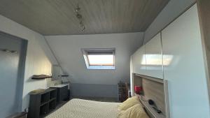 a bedroom with a bed with a mirror and a window at Entre terre et mer in Combrit