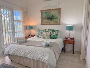a bedroom with a bed with two towels on it at The Estuary Country Estate, Villa "Once Upon A Tide" in Port Edward