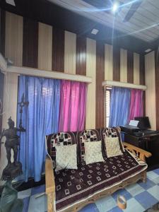 a living room with a couch and blue and pink curtains at Triveni Bliss in Prayagraj