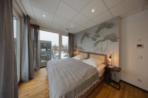 a bedroom with a bed and a large window at HYGGE HOMES Apartment 'Scandi Sunset' in Winsen