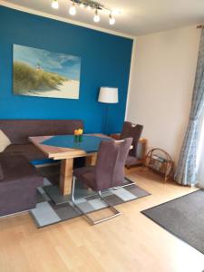 a living room with a table and a couch at Haus Deichblick in Dornum