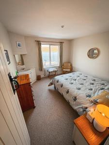 a bedroom with a bed and a sink and a window at Smiley's Cottage in Doagh