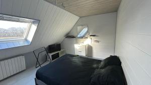 a small room with a bed and a window at Entre terre et mer in Combrit
