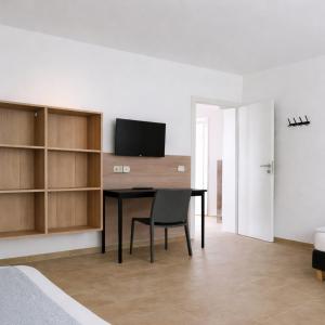 a room with a desk with a chair and a television at Monteurzimmer24-Leuna in Leuna