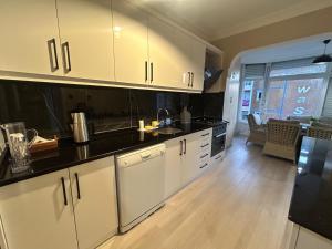a kitchen with white cabinets and black counter tops at No 8 Suite in Alanya +1 photo