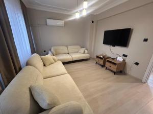 a living room with a couch and a flat screen tv at No 8 Suite in Alanya
