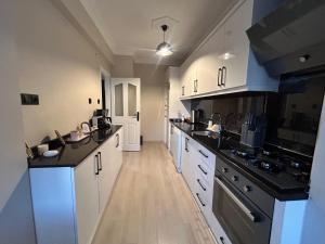 a large kitchen with white cabinets and black counter tops at No 8 Suite in Alanya