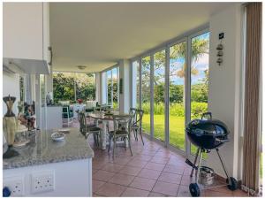 a kitchen with a patio with a table and chairs at The Estuary Country Estate, Villa "Once Upon A Tide" in Port Edward