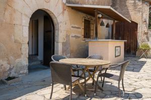 a wooden table and chairs in front of a building at AT504 Rustic house with private pool in Roda de Bará