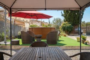 a wooden table and chairs with an umbrella at AT504 Rustic house with private pool in Roda de Bará