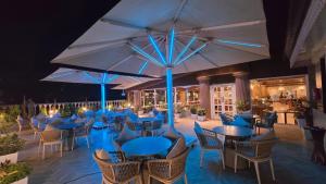 a restaurant with blue tables and chairs and umbrellas at Sarovar Premiere Srinagar in Srinagar