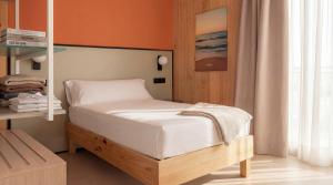 a small bedroom with a bed with orange walls at Kora Olea in Torremolinos +46 photos