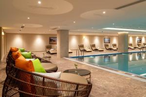 a hotel lobby with a swimming pool and chairs at Golden Sun Hotel - Dalat in Da Lat