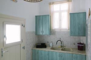 a kitchen with blue cabinets and a sink at Anna's House in Koufonisia +32 photos