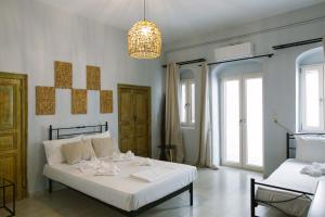 a bedroom with a white bed and a chandelier at Anna's House in Koufonisia