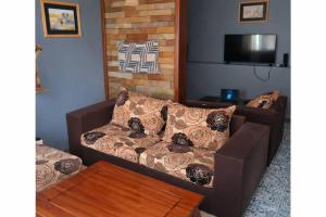 a living room with a couch and a tv at COLIBRI VILLA City Center in Gisenyi