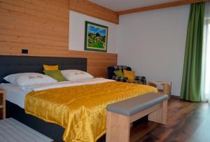 um quarto com uma cama grande e um cobertor amarelo em Guest House Gostišče Jutriša em Rogatec
